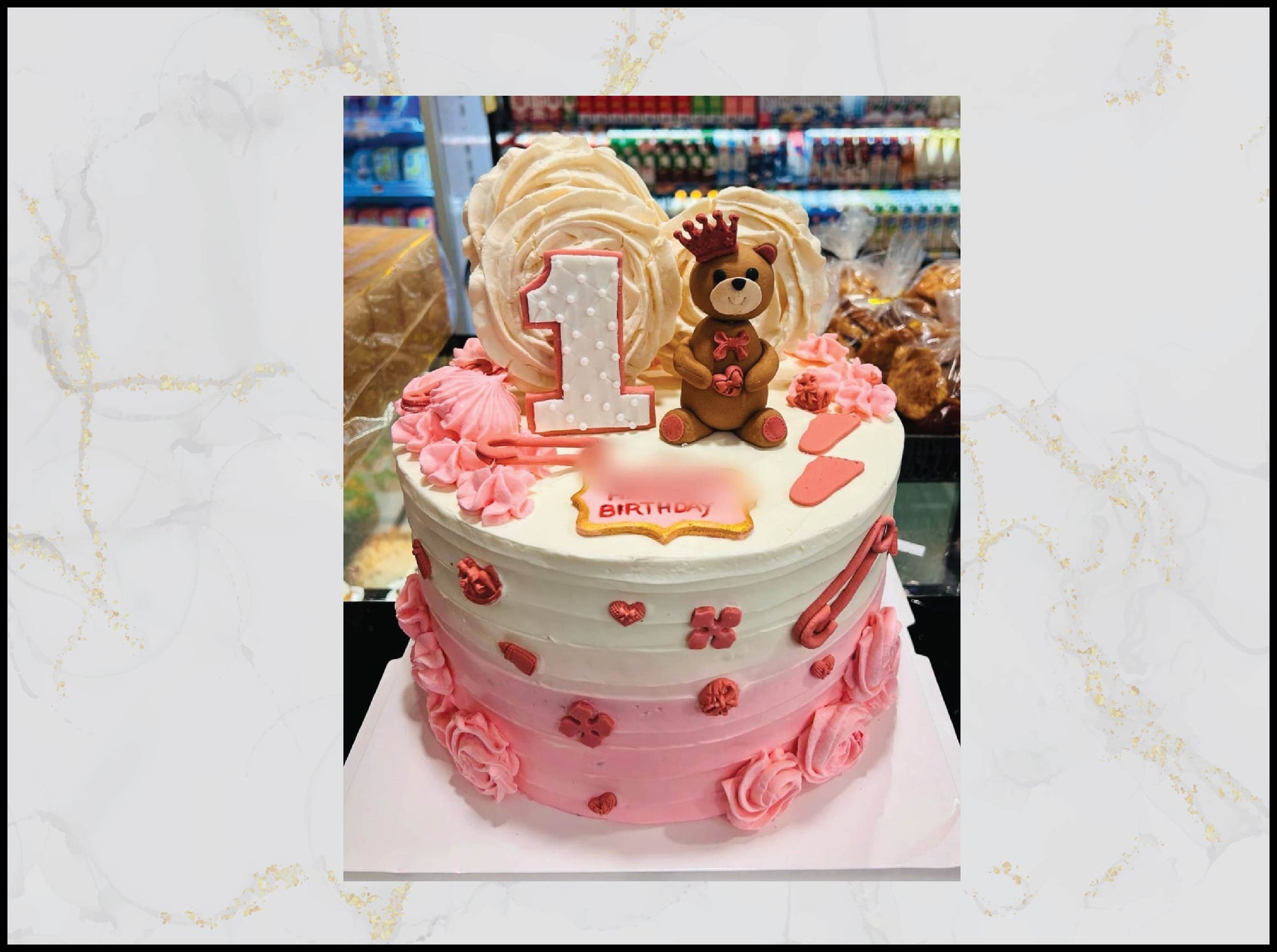 Two-tiered birthday cake with pink and white frosting, teddy bear decoration, and '1st Birthday' sign. macau cake